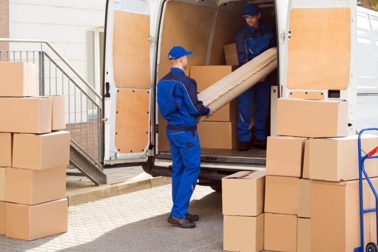 Dos operarios cargando cajas y muebles en una furgoneta de mudanzas, en un servicio de Rapid Services Enterprise en Granada