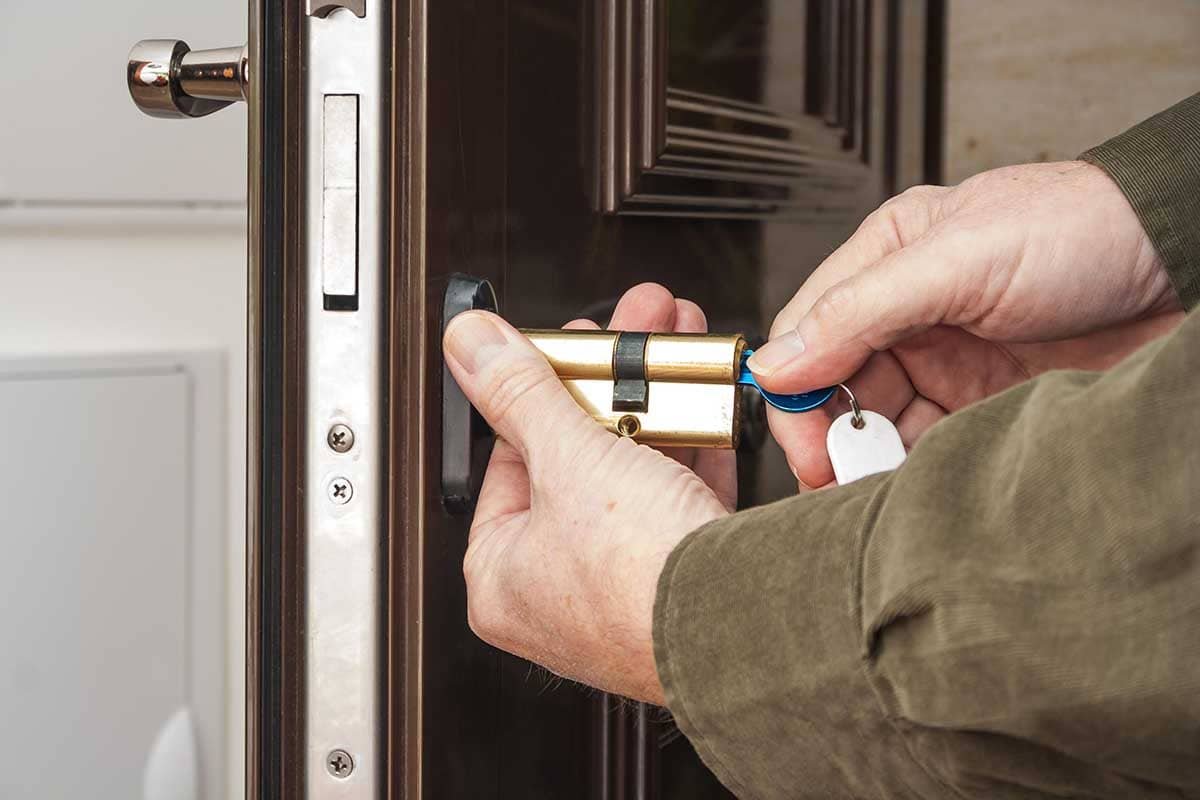 Manos instalando un bombín de seguridad en la cerradura de una puerta en A Coruña